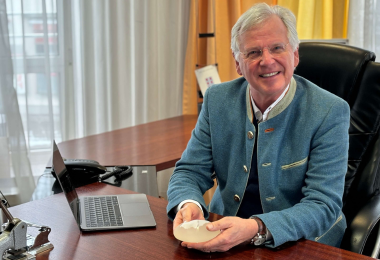 Dr. von Finckenstein hält Brustimplantat in der Hand um Patientin zu beraten